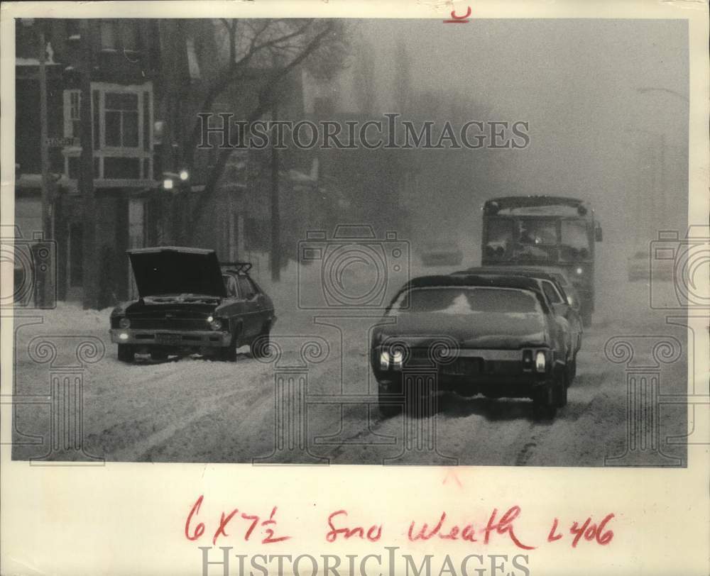 1978 Press Photo Traffic moves past stalled car during snowstorm, Milwaukee - Historic Images