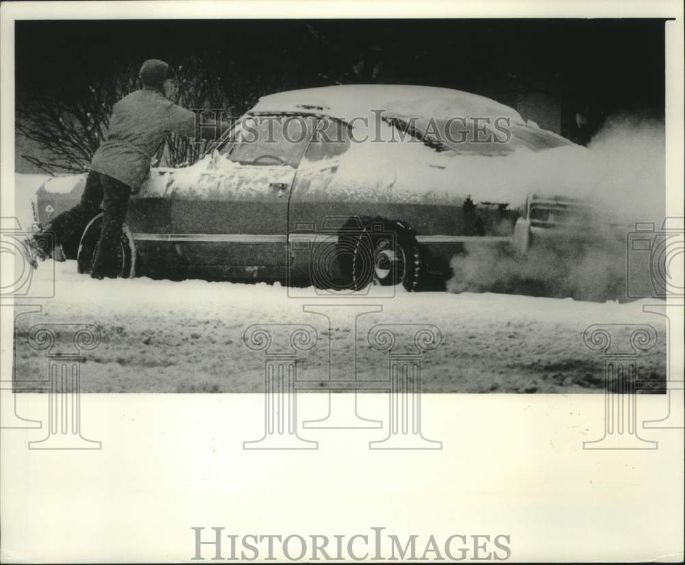 1977 Press Photo Downtown worker brushing snow off her car, Milwaukee - Historic Images