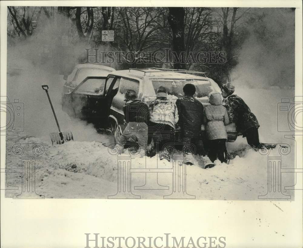 1977 Press Photo Teenagers pushing cars out of snow, Milwaukee - mjc29068 - Historic Images
