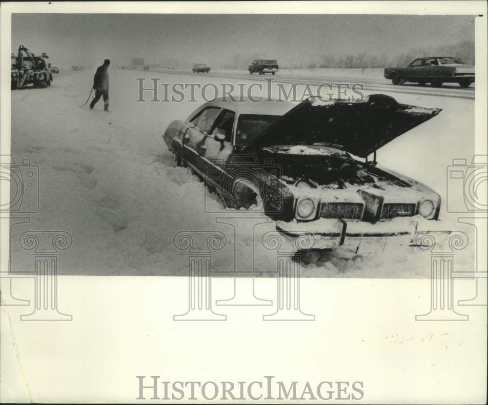 1977 Press Photo Jeff Ribar, Plaza Towing Service about to pull car Wisconsin - Historic Images