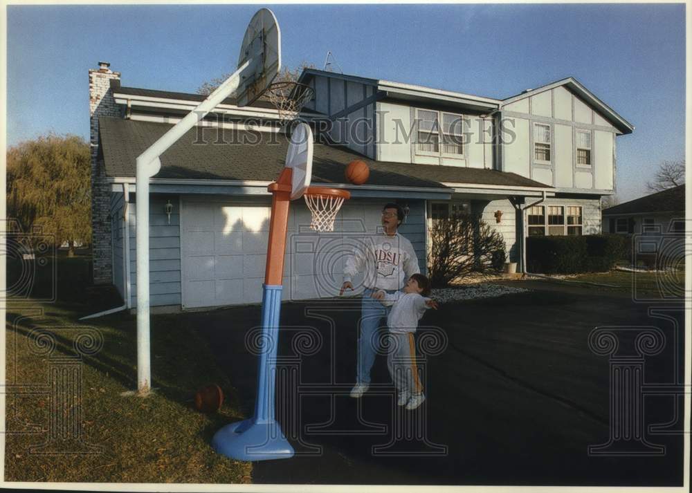 1993 Press Photo Radio man Charles Sykes and son Jay play basketball at home - Historic Images