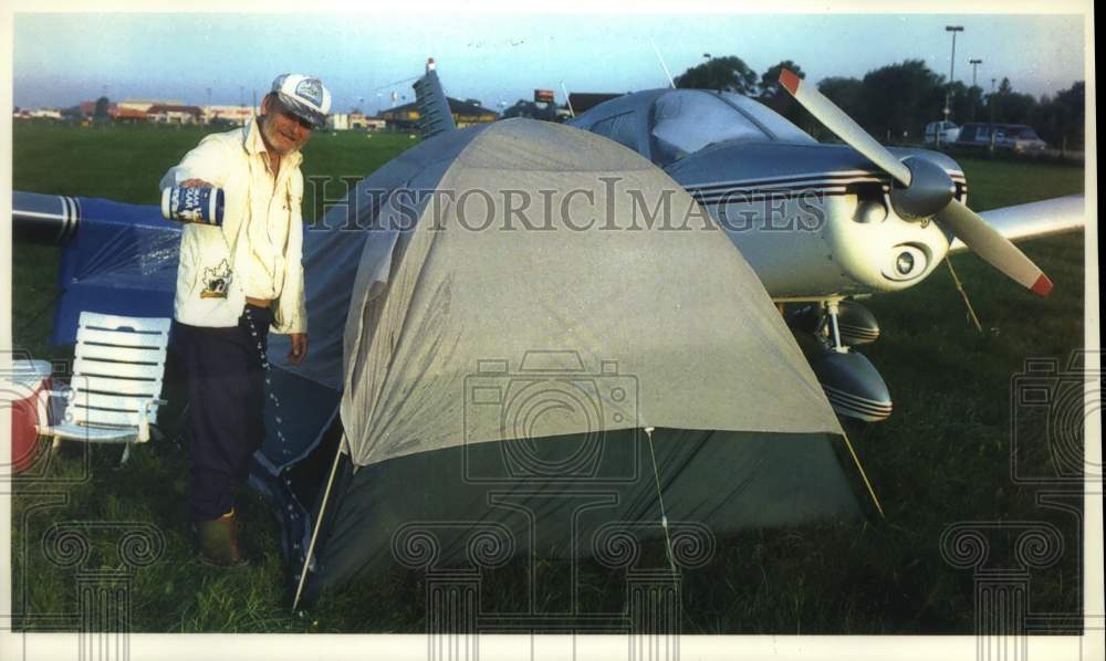 1993 Press Photo Carl Rodgers bails water from tent at Whittman Airport - Historic Images