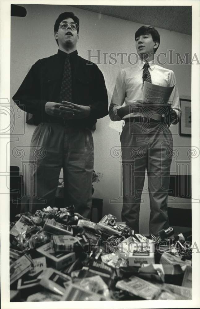 1992 Press Photo Victor Dejesus &amp; Jamie Wall in front of pile of cigarette packs - Historic Images