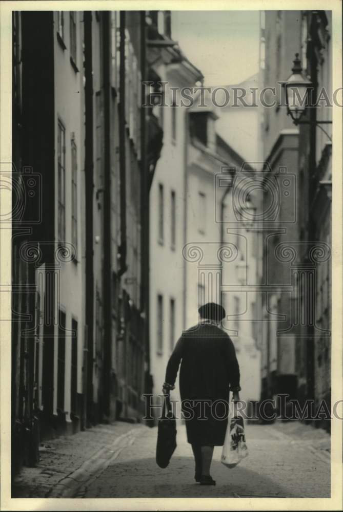 1985 Press Photo Stockholm shopper returns home with purchases in Marlboro bag - Historic Images