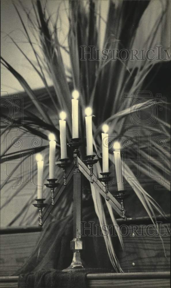 1984 Press Photo Candles lit in front of palm fronds - mjc30034 - Historic Images
