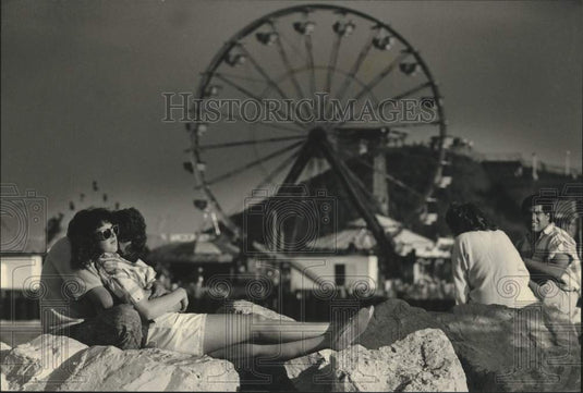 1989 Press Photo A couple sit on rocks near shore of Lake Michigan at Summerfest - Historic Images