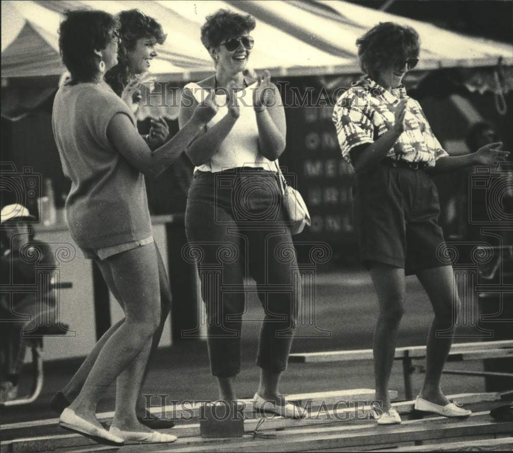 1985 Press Photo Summerfest visitors dancing on benches at Main Stage, Milwaukee - Historic Images