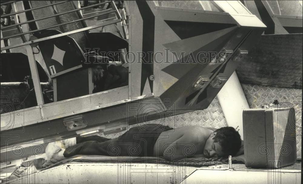 1990 Press Photo Worker Paul Hoffpauir sleeps after dismantling Summerfest rides - Historic Images