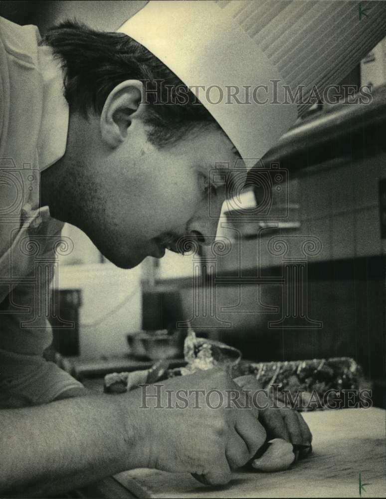 1986 Press Photo Chef Springer cutting wedge from baby acorn squash, Milwaukee - Historic Images