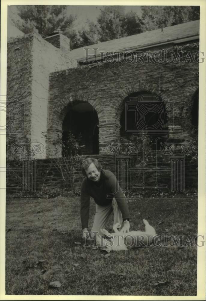 1979 Press Photo Sol Stein plays with his dog at home in Scarborough New York. - Historic Images