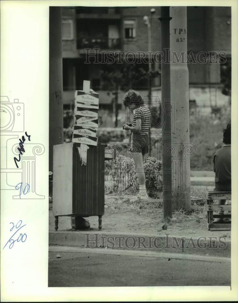 1982 Press Photo Boy selling black-market cigarets on street corner in Naples - Historic Images