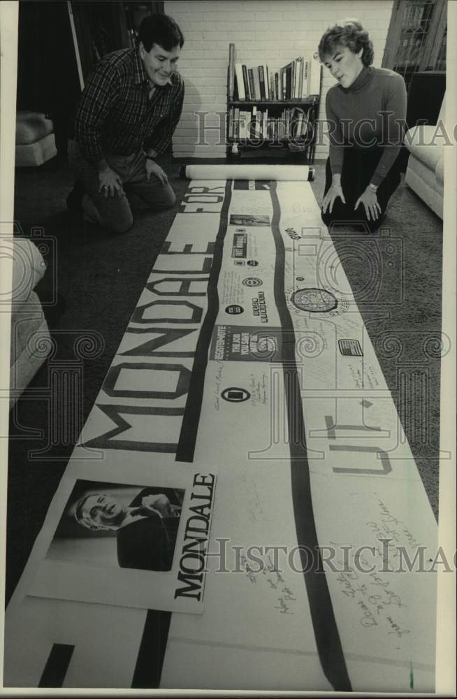 1984 Press Photo Michael &amp; Ellen Bartell examine Walter Mondale banner - Historic Images