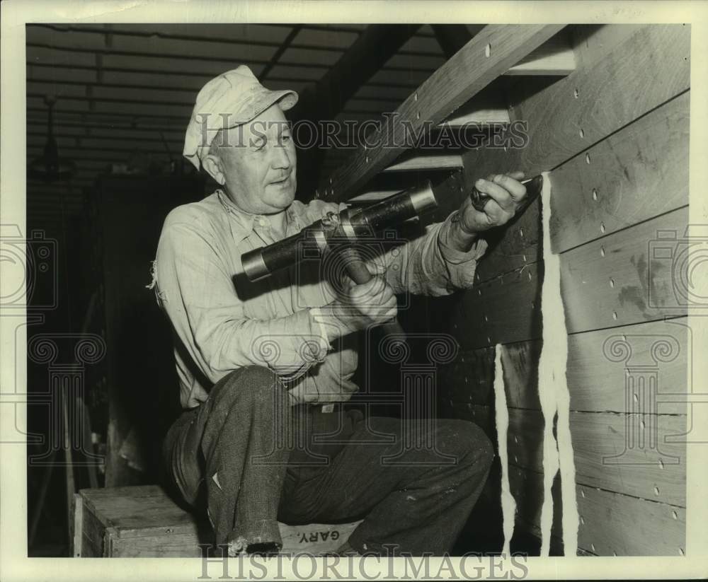 Press Photo Unidentified man caulking gaps in boards - mjc31093 - Historic Images