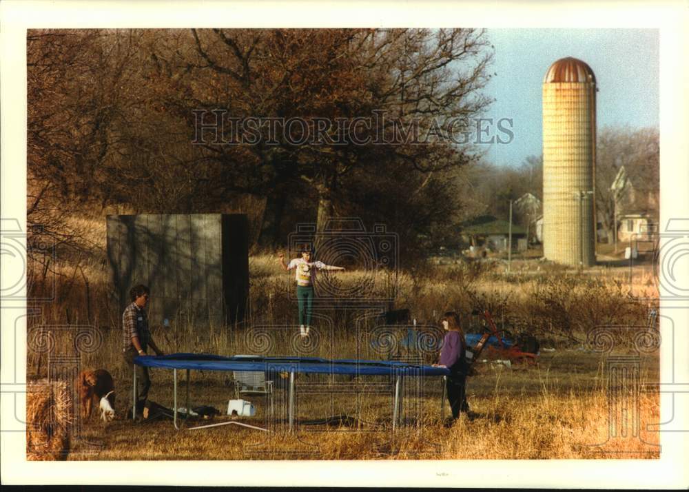 1994 Press Photo Melissa Heath on trampoline while father &amp; sister watch, Wales - Historic Images