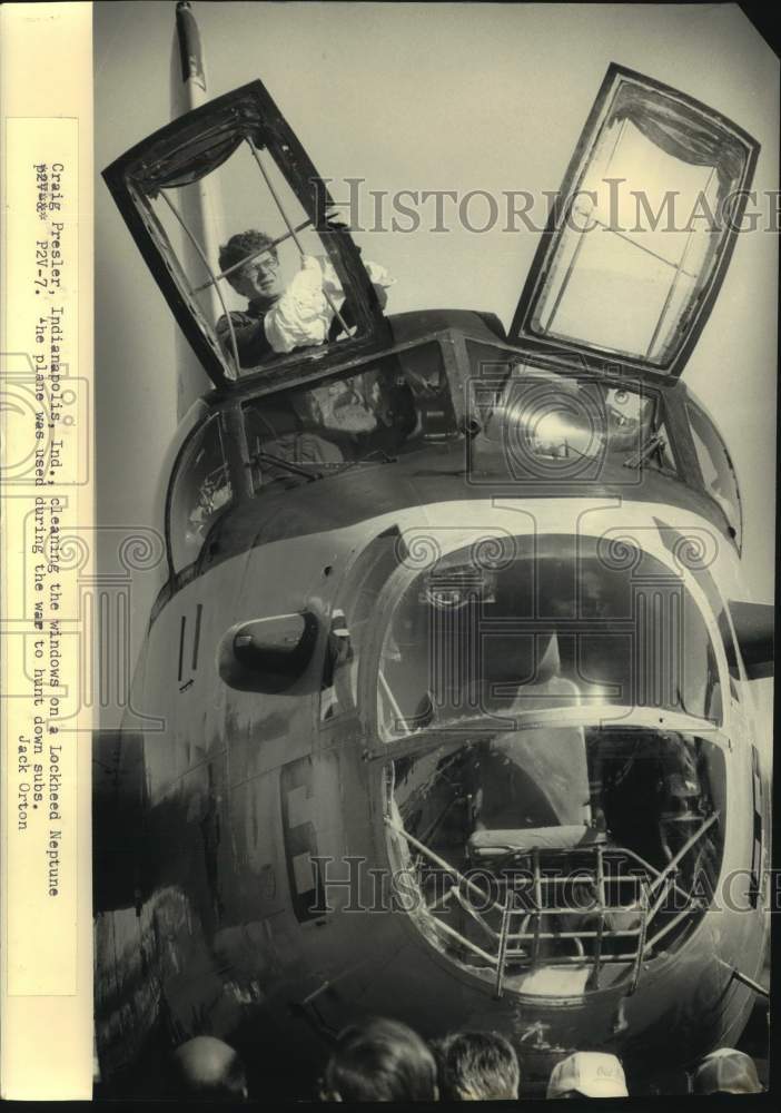 1986 Press Photo Craig Presler cleans windows on Lockheed Neptune, Wisconsin - Historic Images