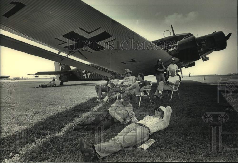 1986 Press Photo John Taylor and Fred Rhodes under airplane wing in Wisconsin - Historic Images