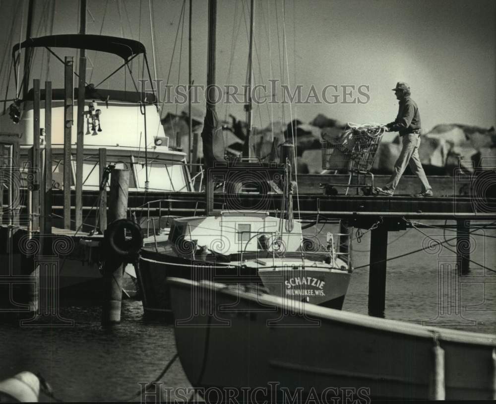 1989 Press Photo Ray Hernday walking on the pier at South Shore Yacht Club, WI - Historic Images