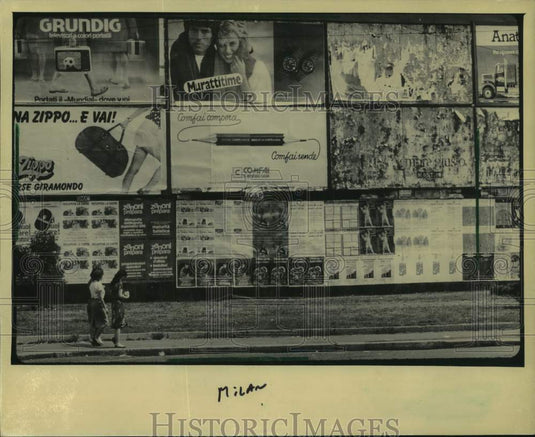 1982 Press Photo A cluster of signs greeted two walkers in Milan, Italy - Historic Images