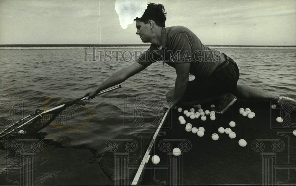 1992 Press Photo Mike Pinterics scoops golf balls from water during Summerfest - Historic Images