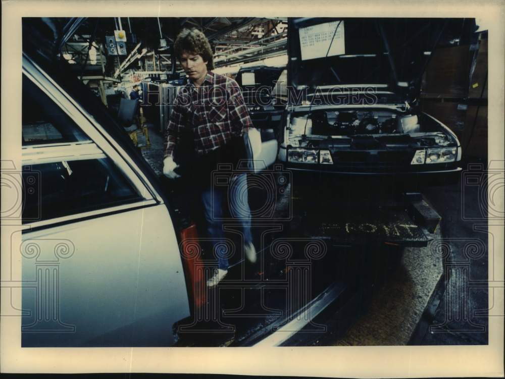 1989 Press Photo Paul Steinke installs bumpers for General Motors automobiles - Historic Images