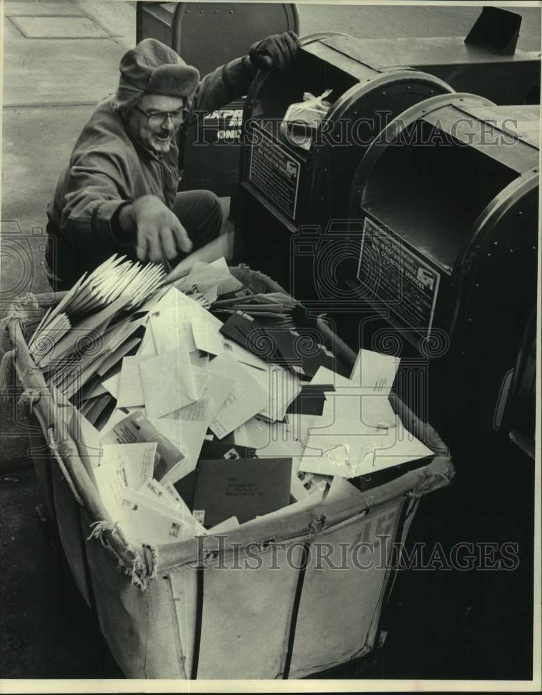 1986 Press Photo Milwaukee postal employee Art Weber empties out mailbox - Historic Images