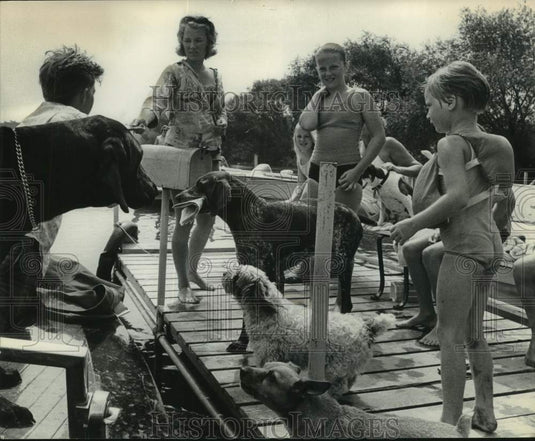 1984 Press Photo Mail Carrier delivers mail on a boat to family on dock - Historic Images