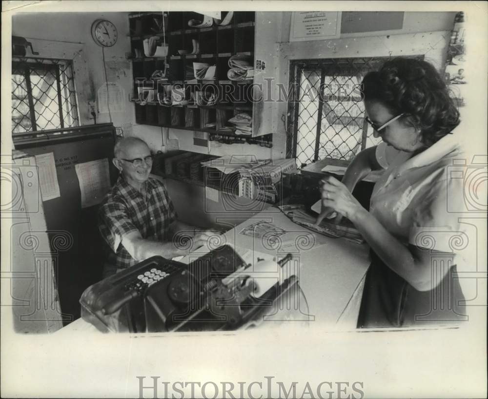 1971, Mr Brown with customer at post office United States - mjc32519 - Historic Images
