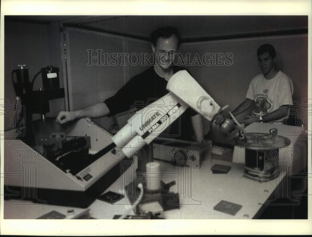 1993 Press Photo Anthony Woods and Rob Schneider with robotic arm Illinois - Historic Images