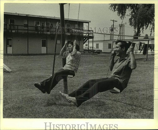 1979 Press Photo Migrant Workers at Texas Camp, Belgium relax on swings - Historic Images