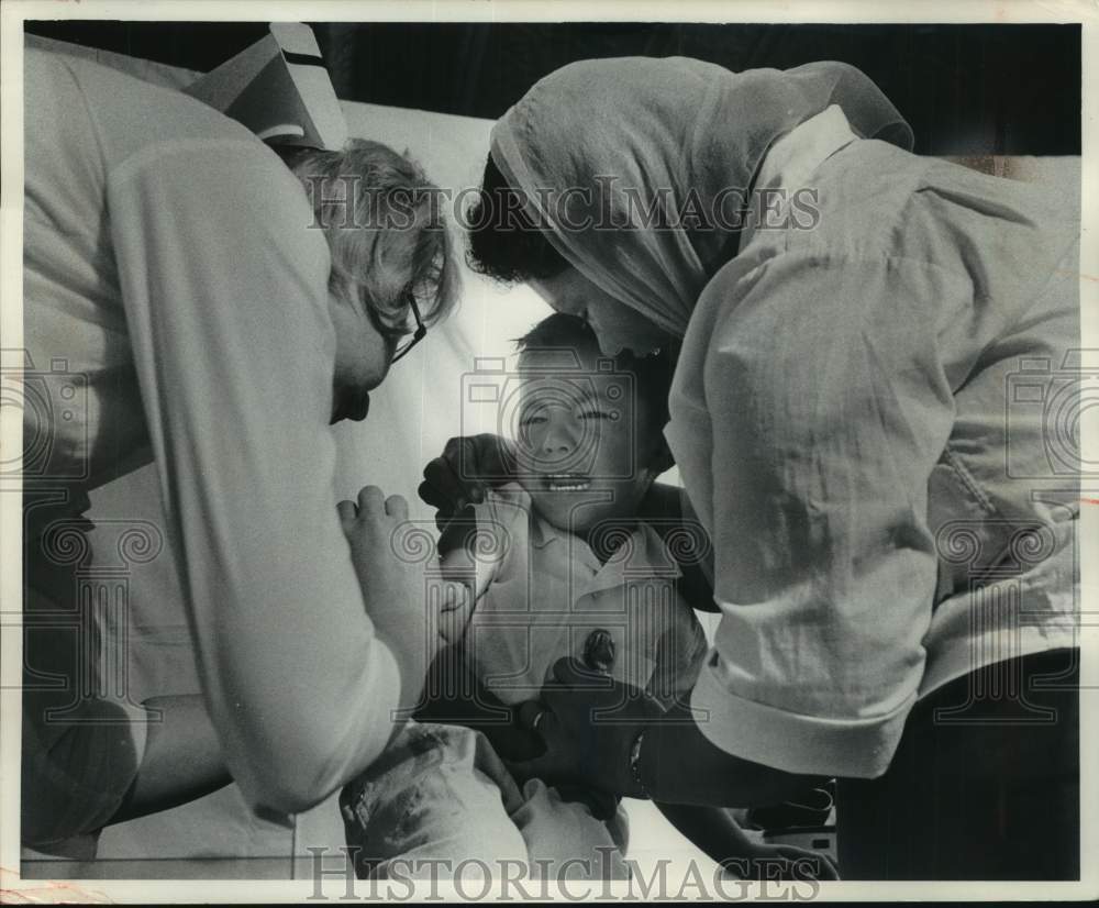 1965, Ruben Oritz getting a shot with nurse and his mother Green Bay - Historic Images