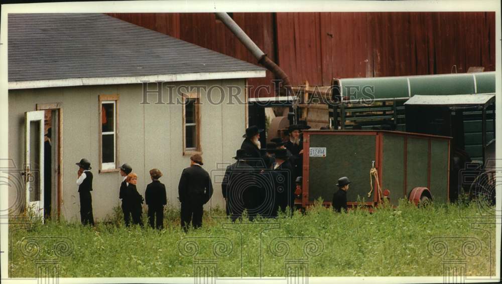 1993 Press Photo Amish boy peering into doorway at a funeral service, Wisconsin - Historic Images
