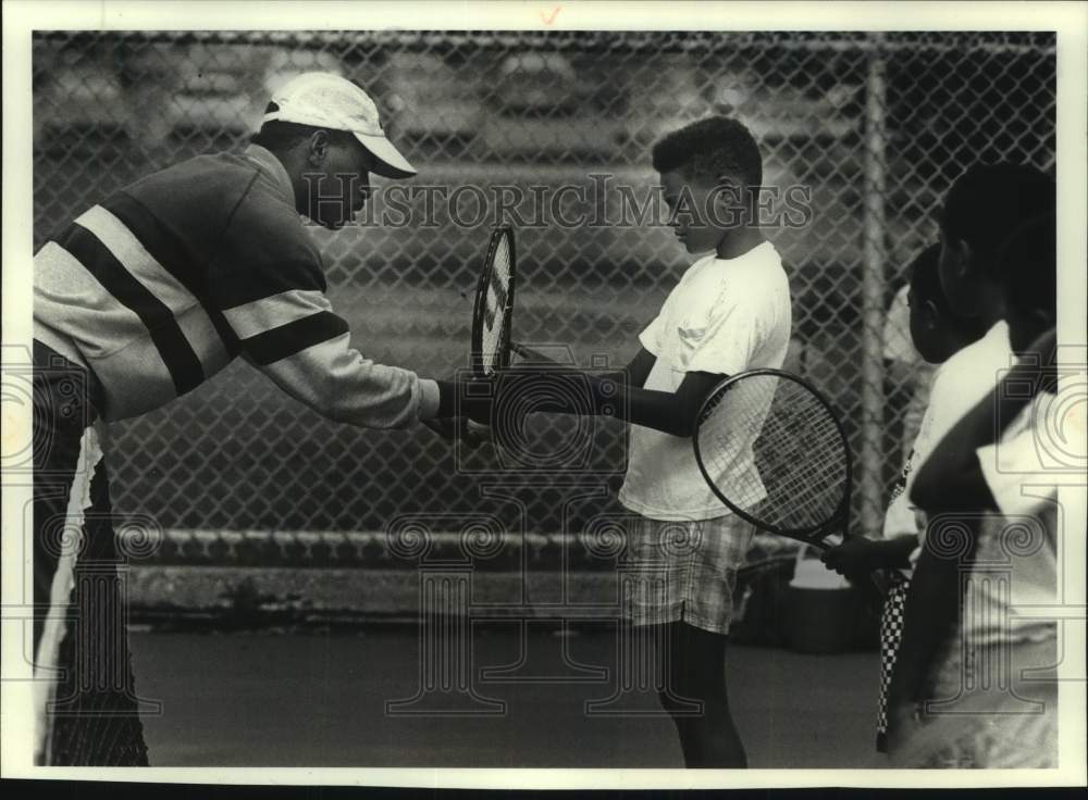 1990 Press Photo Tennis instructor Michael Levy teaches Dante Stanley. - Historic Images