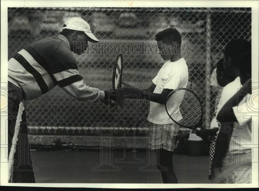 1990 Press Photo Tennis instructor Michael Levy teaches Dante Stanley. - Historic Images
