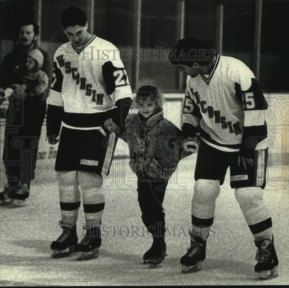 1990 Press Photo Natalie Anderson gets skating lesson from Wisconsin players.` - Historic Images
