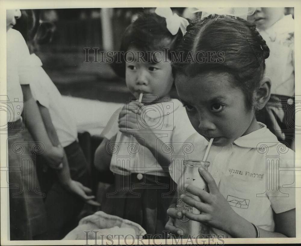 1961 Press Photo Children in Thailand drink powdered milk from United States - Historic Images