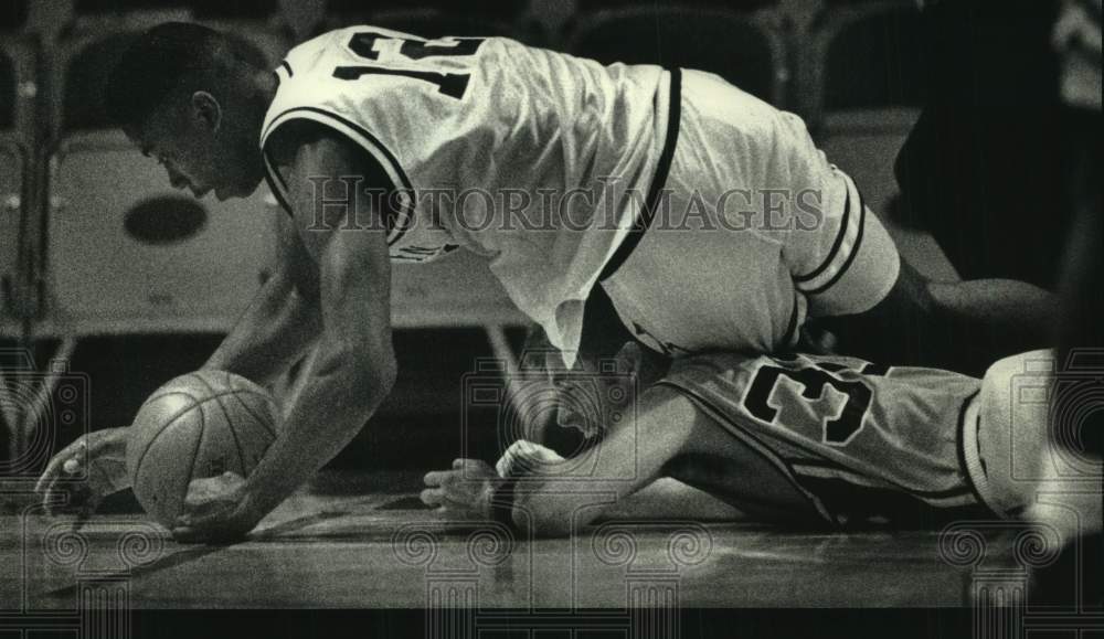 1992 Press Photo Leon McGee rolls over Pat Easterlin during basketball game - Historic Images