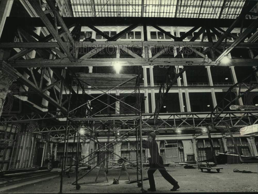 1990, Man rolls scaffolding across atrium, old post office, Milwaukee - Historic Images