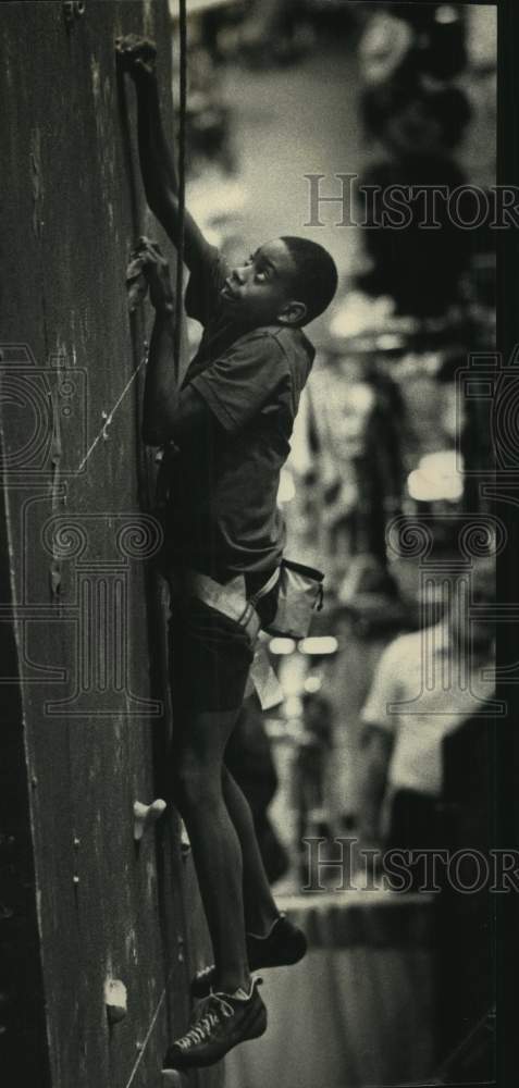1992 Press Photo George Lewis climbs the rock wall at the Milwaukee Sports Show - Historic Images