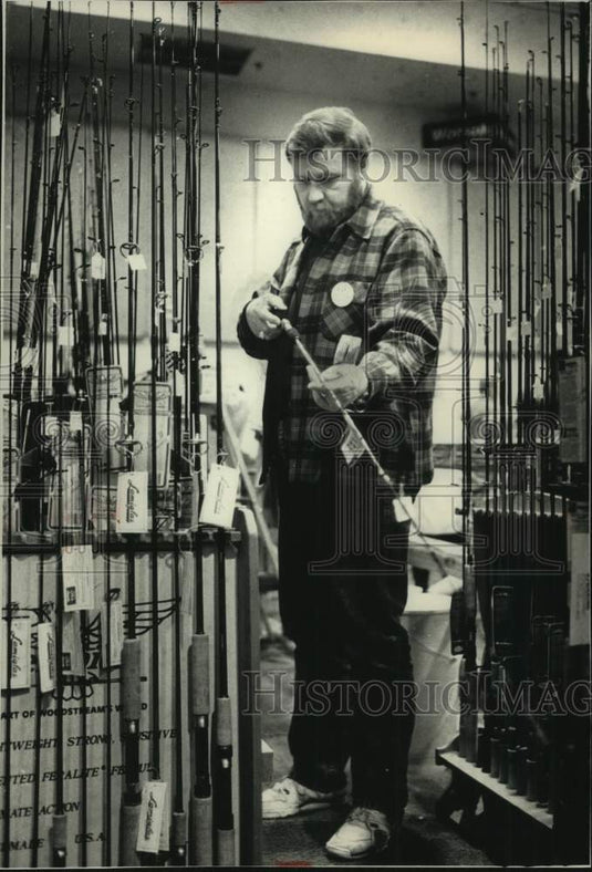 1989 Press Photo Dave Kunelius inspects rod at Milwaukee Sentinel Sports Show - Historic Images