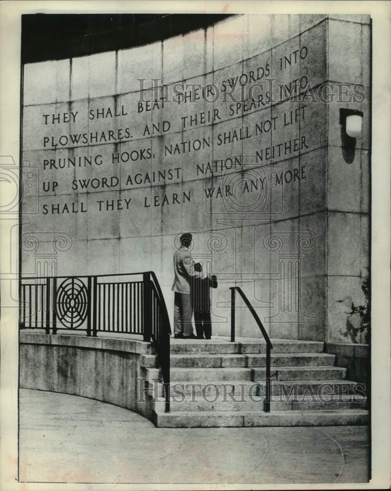 1960 Press Photo Father and son read Isaiah 11:4 carved into wall, New York.- Historic Images