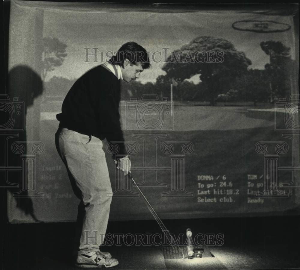 1993 Press Photo Tom Held pitches a golf ball at InGolf simulator in Milwaukee - Historic Images
