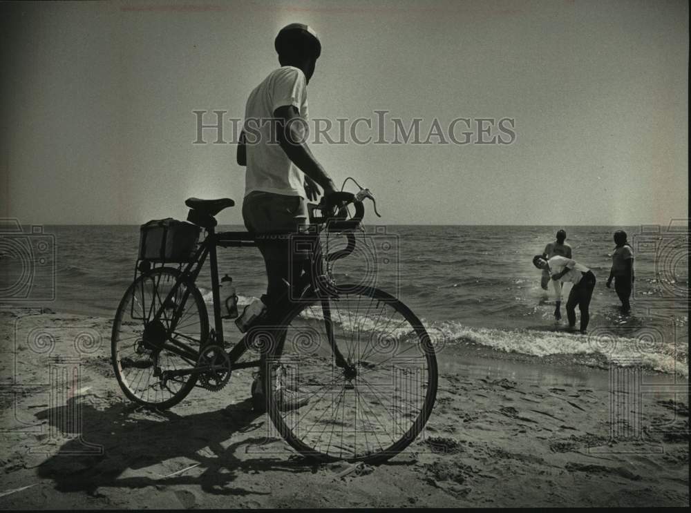 1989 Press Photo Karl Kohrus watches cyclists cool off, Lake Michigan Two Rivers - Historic Images