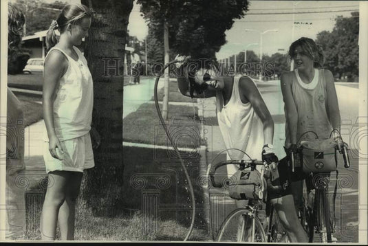 1988 Press Photo Kerri Knop cools off with garden hose, with others on SAAGBRAW - Historic Images