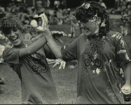 1984 Press Photo Cyclists Carol Schaenzer & Gayla Greis in a shaving cream fight - Historic Images