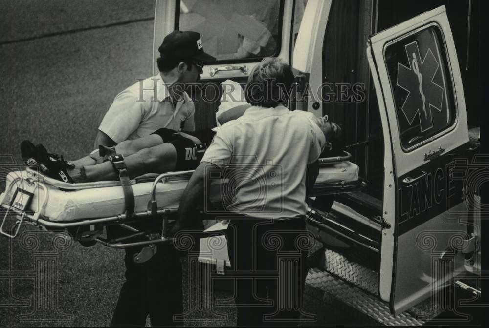 1985 Press Photo James Loesche put in ambulance after Milwaukee Classic accident - Historic Images