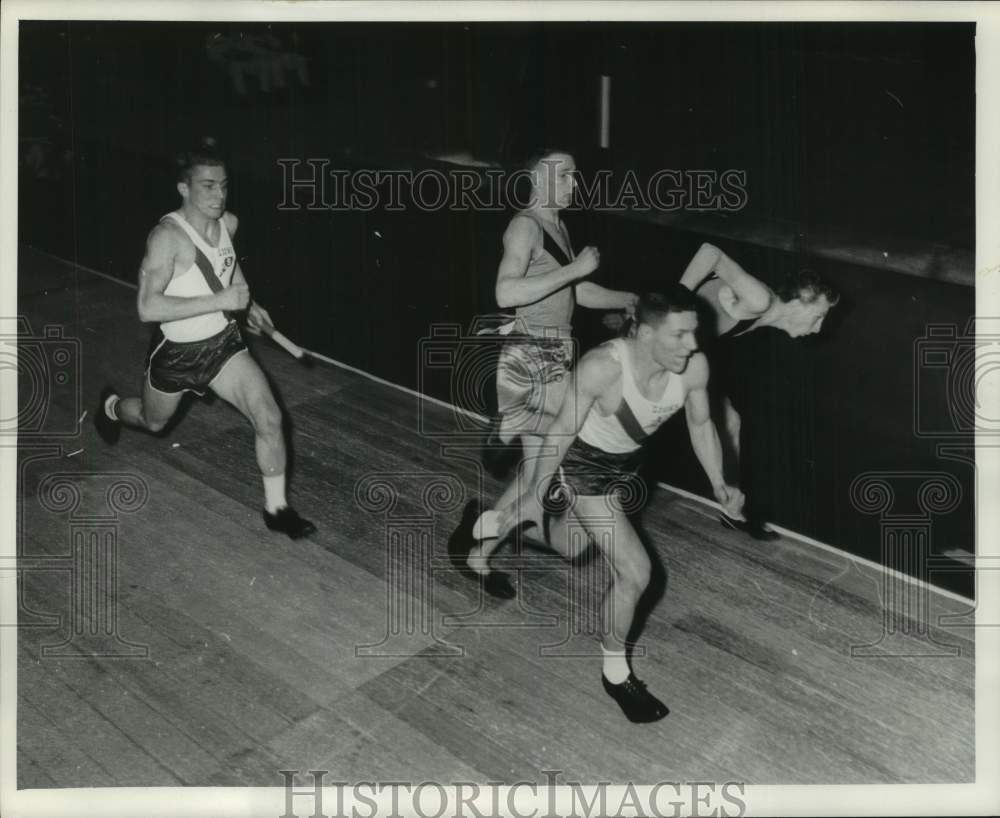 1960 Press Photo Runners hand baton during relay race at Milwaukee Track Meet - Historic Images