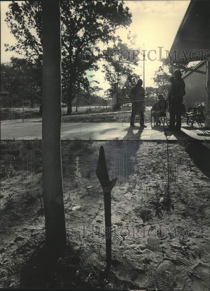1984 Press Photo Tribal members guard bingo hall, war club stuck in ground. - Historic Images