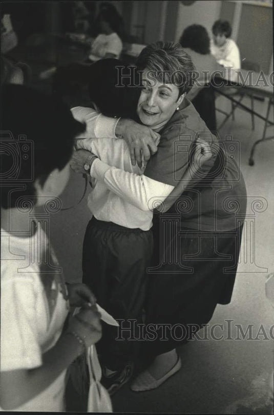 1990 Press Photo Beverly Ugent hugs Indian Hill Elementary School pupil - Historic Images