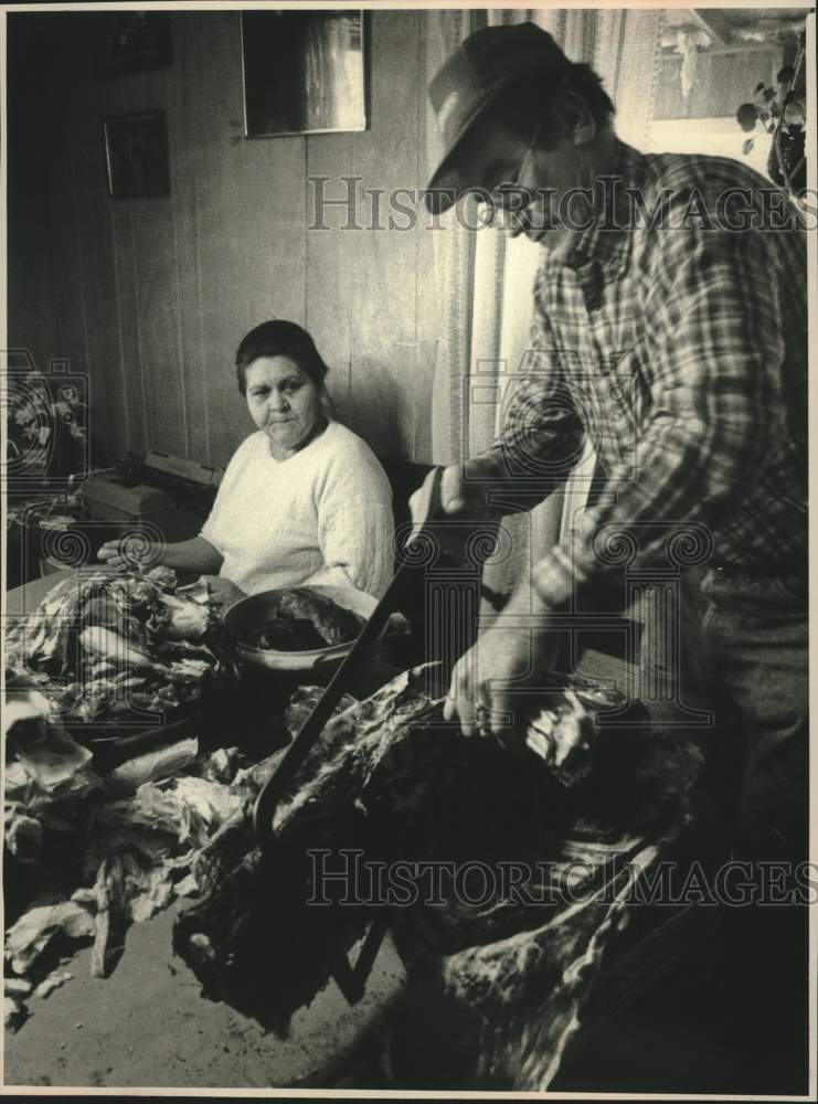 1988 Press Photo Dolores Beaudin watches husband butcher deer on dining table. - Historic Images