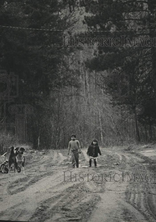 1973, Two youngsters chasing a dog along street at edge of New Post. - Historic Images